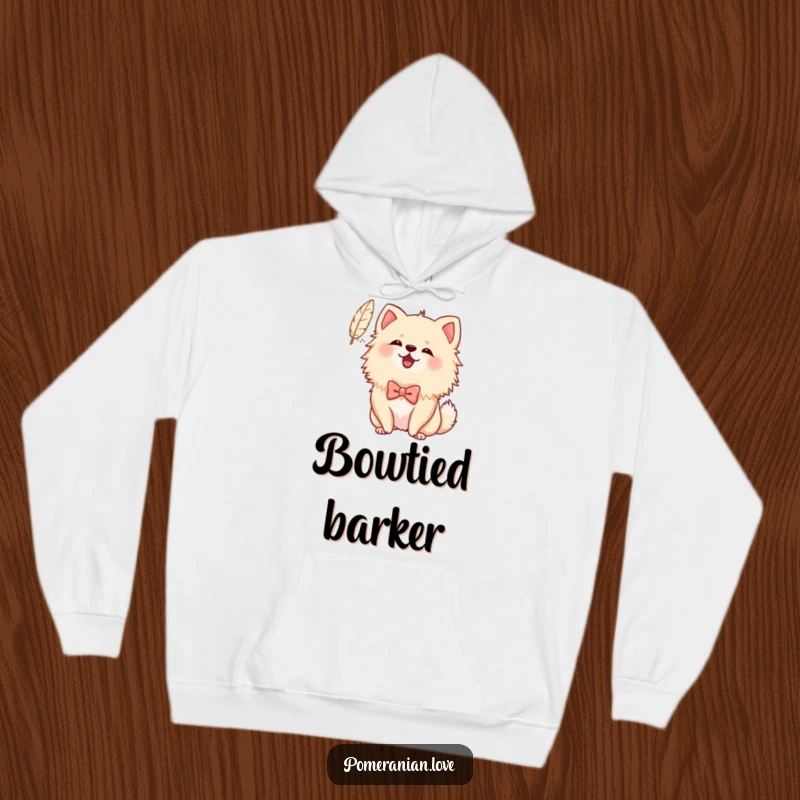 Funny Bowed Pomeranian Hoodie: Cozy sweatshirt featuring a Pomeranian with a bow cheerfully barking at a floating feather, full of playful charm.