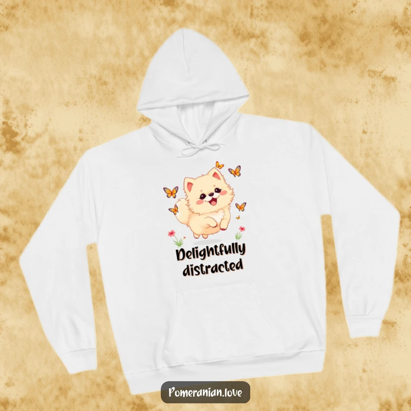 Funny Pomeranian hoodie featuring a dog joyfully chasing butterflies, radiating warmth and whimsical delight.