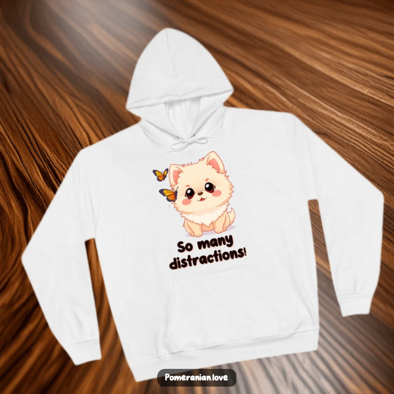 Funny Pomeranian hoodie featuring a dog with wide eyes observing a fluttering butterfly. Evokes a sense of wonder and gentle curiosity.