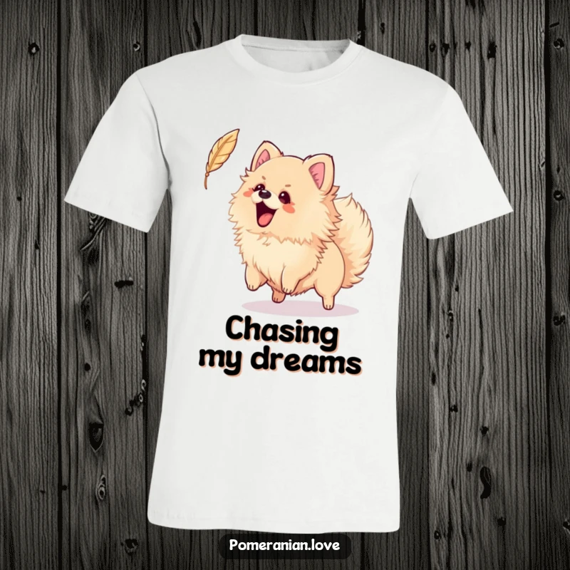 Funny t-shirt depicting an energetic Pomeranian wagging its tail, playfully attempting to catch a floating feather in mid-air.